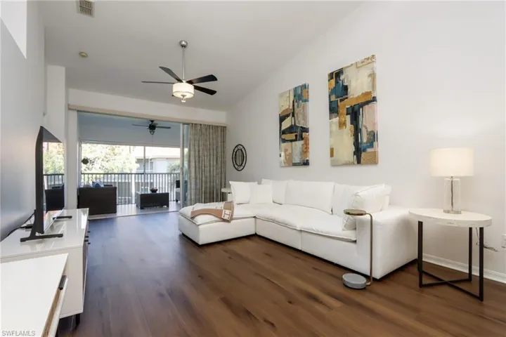 Living area with dark wood-style flooring and ceiling fan