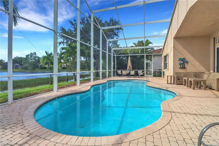 View of swimming pool featuring a lanai and a patio