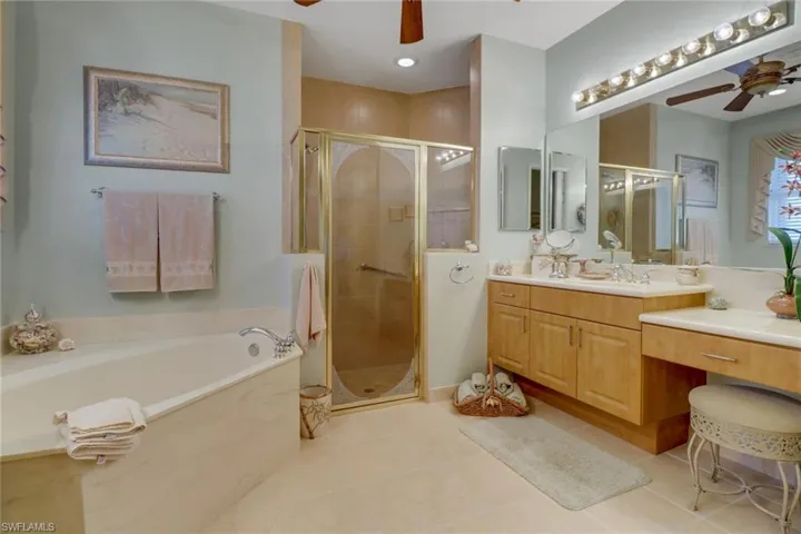 Bathroom featuring ceiling fan, tile patterned flooring, independent shower and bath, and vanity