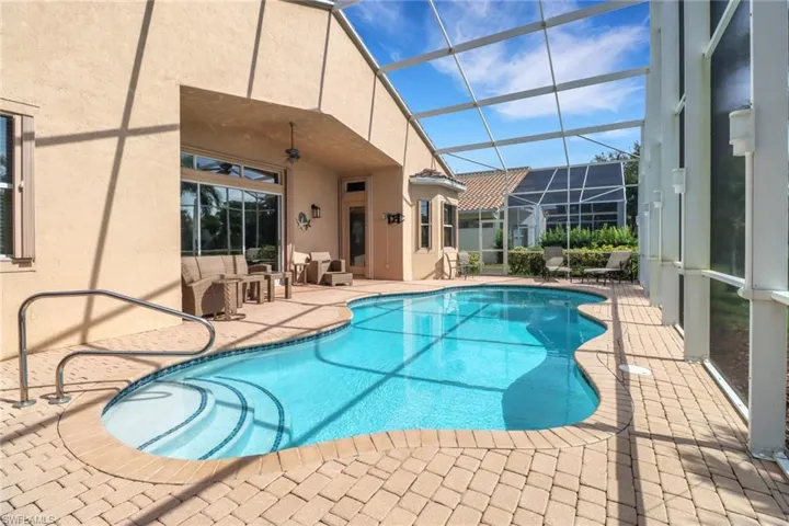 View of swimming pool with glass enclosure, a patio, and ceiling fan