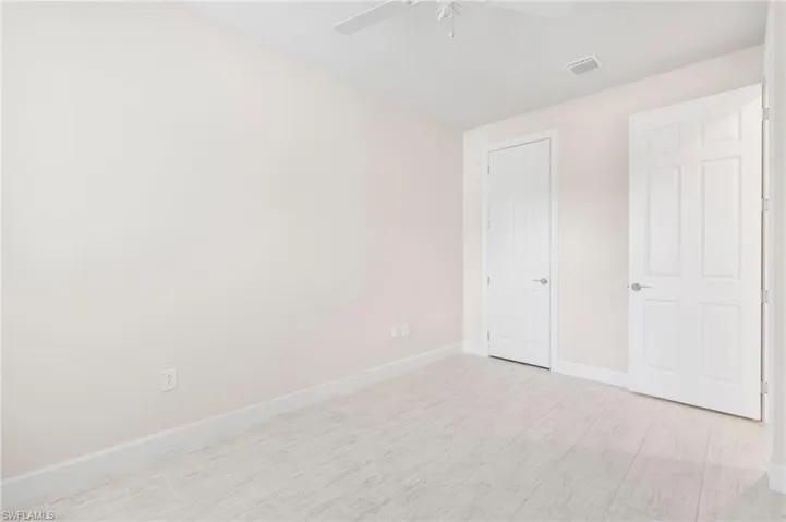 Unfurnished bedroom with baseboards, visible vents, light wood-style flooring, and a ceiling fan