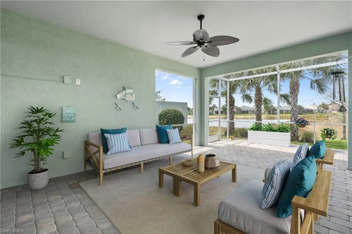View of patio with glass enclosure, an outdoor living space, and ceiling fan