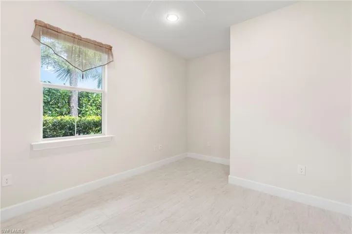 Spare room featuring baseboards and wood finished floors