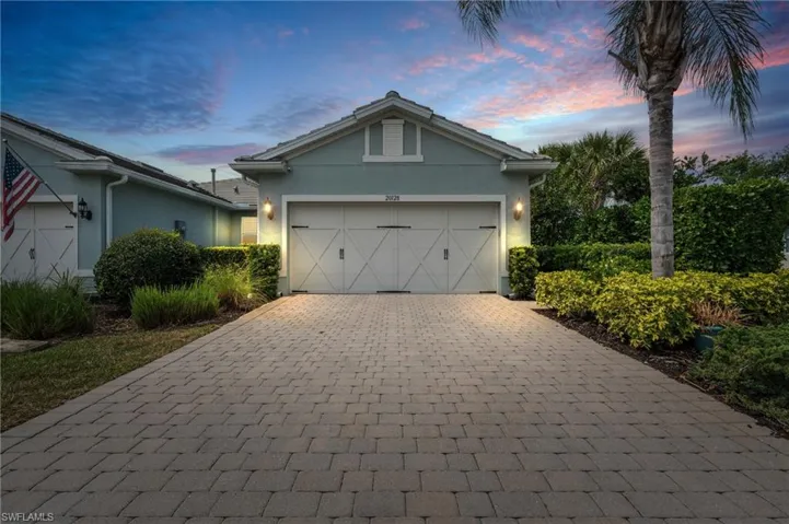 View of front of property featuring stucco siding, a garage, and decorative driveway
