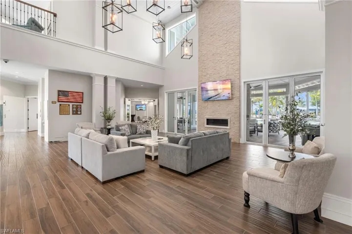 Living room featuring decorative columns, dark wood-type flooring, and a healthy amount of sunlight