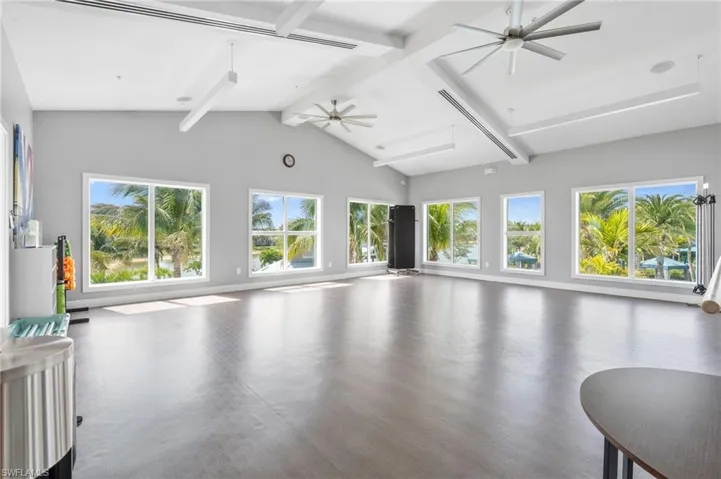 Living area with baseboards, high vaulted ceiling, a ceiling fan, and beam ceiling