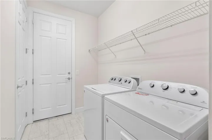 Laundry area featuring baseboards, washer and dryer, and laundry area