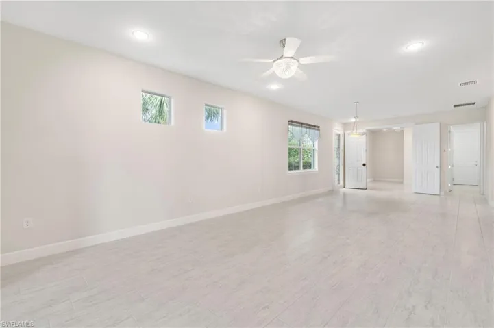 Empty room featuring baseboards, ceiling fan, visible vents, and light wood finished floors