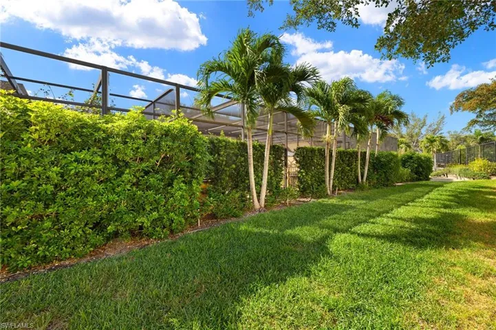 View of yard with glass enclosure and fence