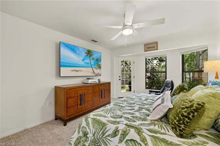 Bedroom featuring baseboards, visible vents, ceiling fan, access to exterior, and light carpet