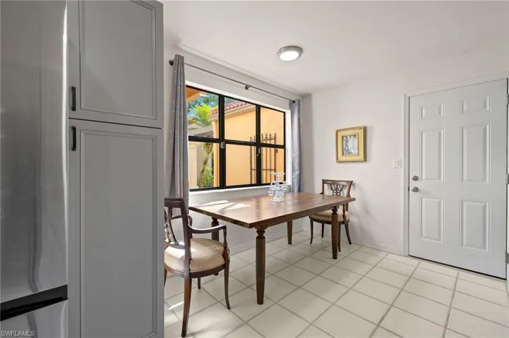 Dining area with light tile patterned floors and baseboards