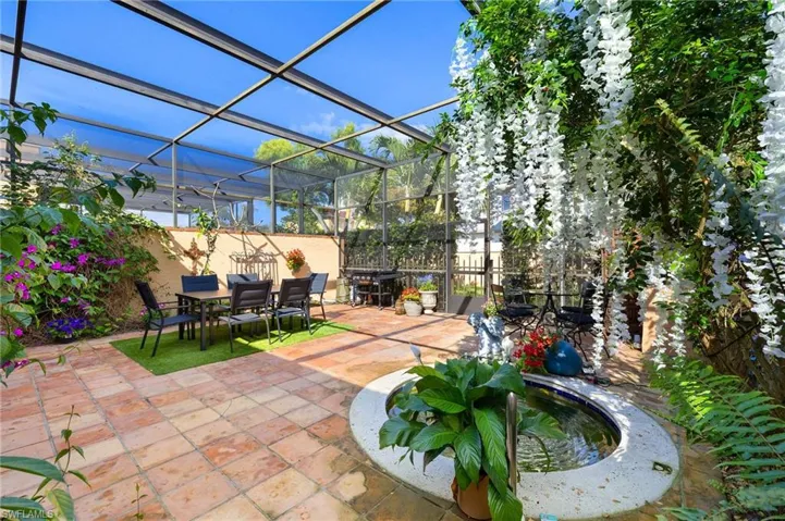View of patio / terrace featuring a screen enclosure, outdoor dining area, Koi Fish and fence