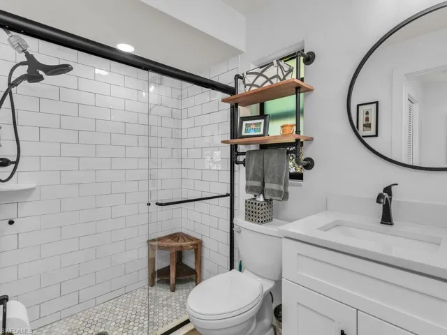 Bathroom with tile patterned flooring, vanity, toilet, and walk in shower