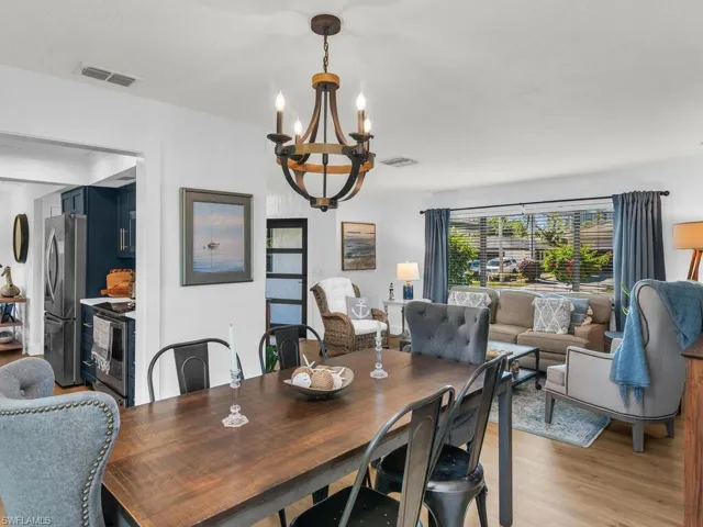 Dining area with light hardwood / wood-style floors and a notable chandelier