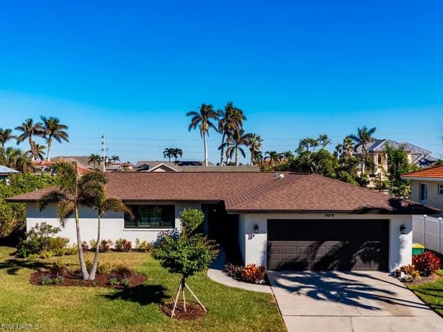 Ranch-style house with a garage and a front lawn