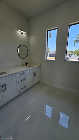 Bathroom with double vanity and light tile patterned floors