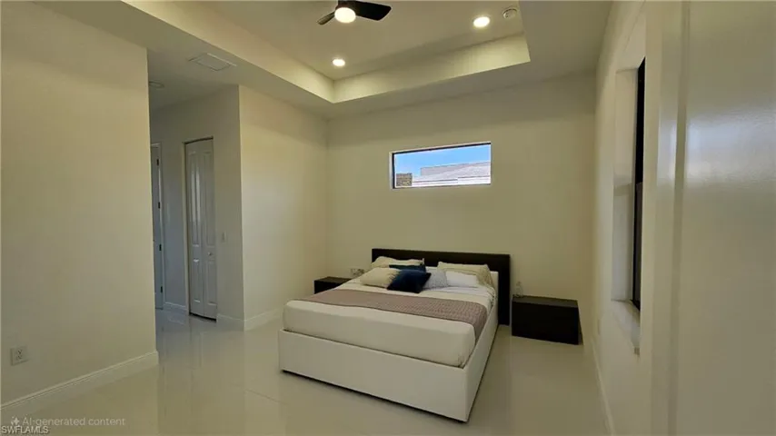 Bedroom with a tray ceiling, light tile patterned floors, recessed lighting, a ceiling fan, and a closet