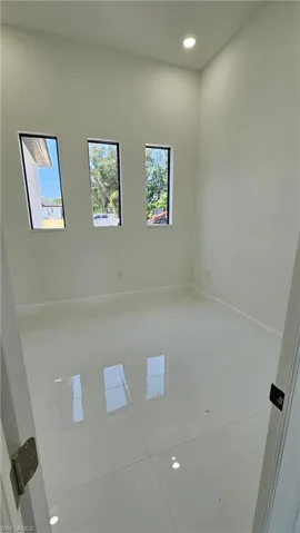 Tiled empty room featuring recessed lighting and baseboards
