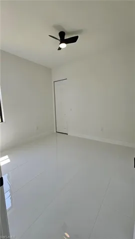 Spare room with ceiling fan and light tile patterned floors