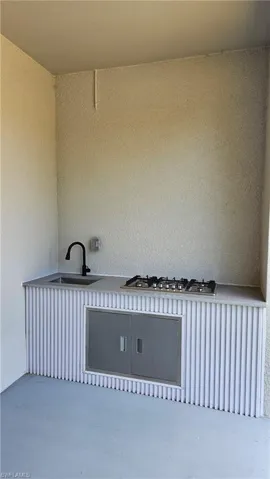 Laundry area with a textured wall and concrete floors