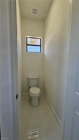 Bathroom with light tile patterned floors and toilet