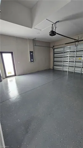 Garage featuring electric panel and a garage door opener