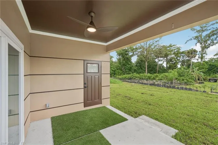 View of yard featuring a patio area, view of scattered trees, and a ceiling fan