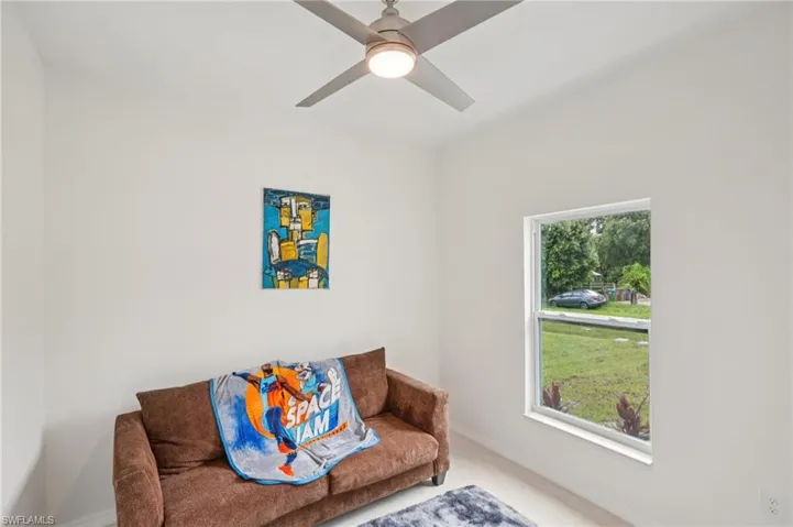 Living area featuring ceiling fan and carpet floors