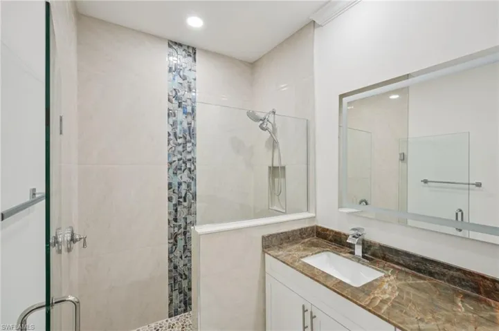 Bathroom featuring a shower stall, vanity, and recessed lighting