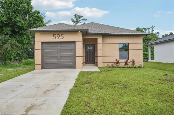 View of front of house featuring concrete driveway, a shingled roof, stucco siding, and an attached garage