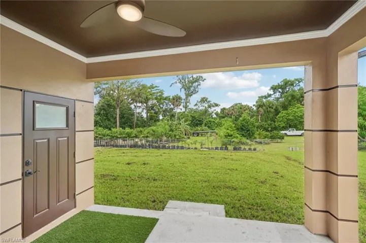 View of yard featuring view of scattered trees, a patio area, and ceiling fan