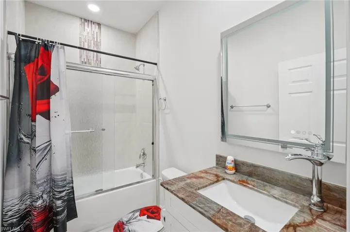 Full bathroom with bath / shower combo with glass door and vanity
