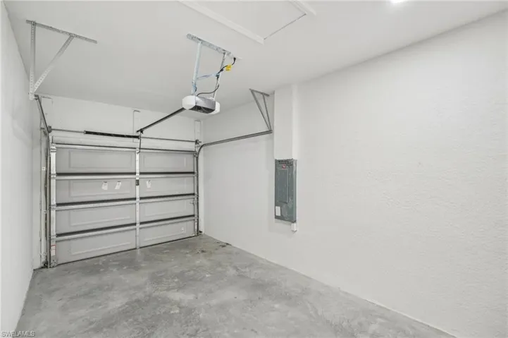 Garage featuring electric panel and a garage door opener