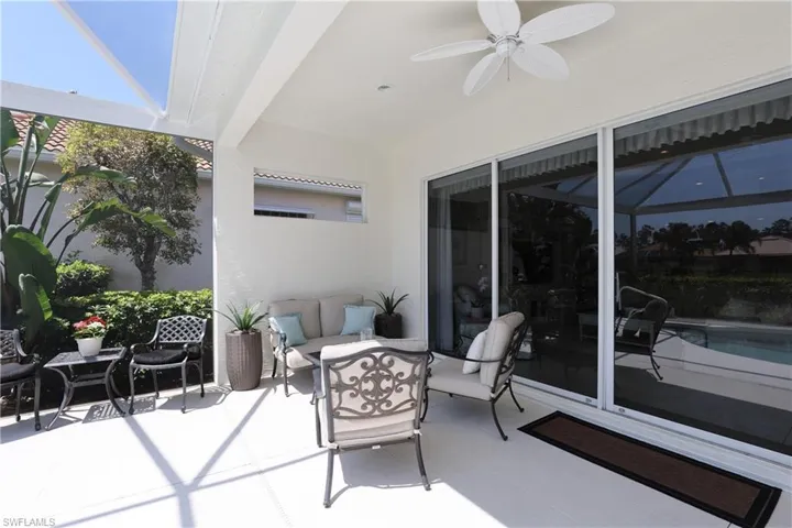 View of patio / terrace featuring a lanai, ceiling fan, and an outdoor pool