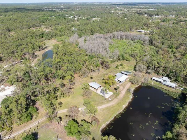 Bird's eye view with a water view and a wooded view