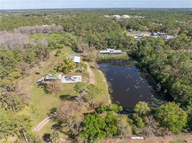 Aerial view with a water view and a forest view