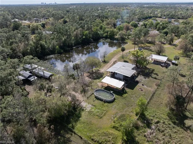 Birds eye view of property with a water view and a forest view