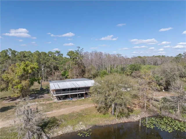 Aerial view with a water view and a wooded view