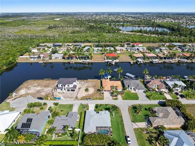 Aerial view of property and surrounding area with a nearby Gulf Acess homes and spreader canal