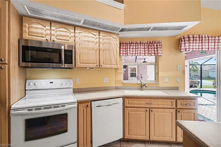 Kitchen with light countertops, and light brown cabinets
