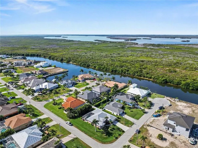 Aerial view of property and surrounding area with a nearby Gulf Acess homes and spreader canal