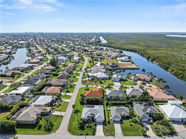 Aerial view of property and surrounding area with a nearby Gulf Acess homes and spreader canal