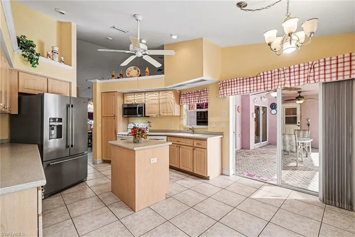 Kitchen with a ceiling fan, a towering ceiling, , a chandelier over breakfast nook, and a center island