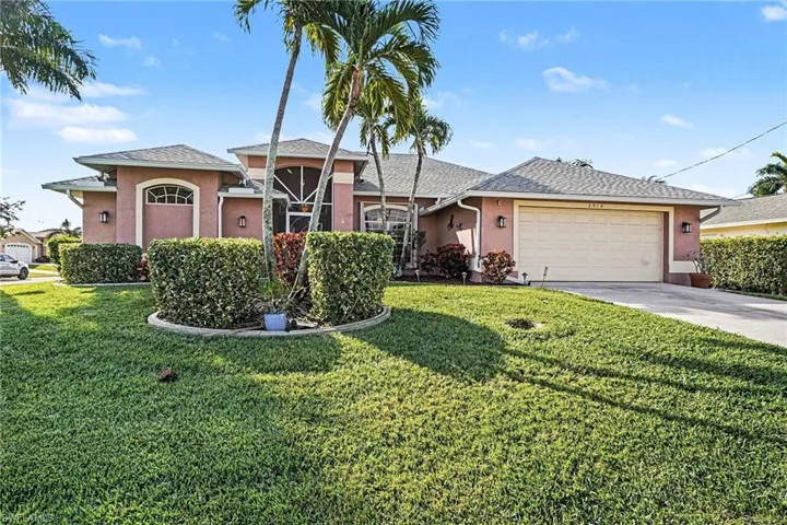 View of front of property with stucco siding, a front yard, a shingled roof, and an attached garage