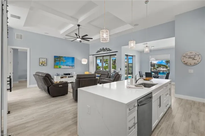 Kitchen featuring white cabinetry, light  wood like tile flooring, sink, coffered ceiling, and dishwasher