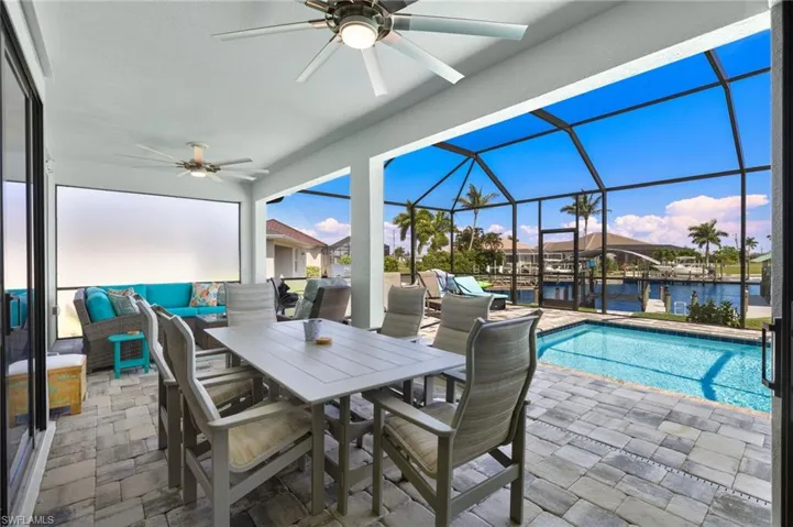 LARGE lanai featuring 2 ceiling fans, eating area, living area with pool and  water views