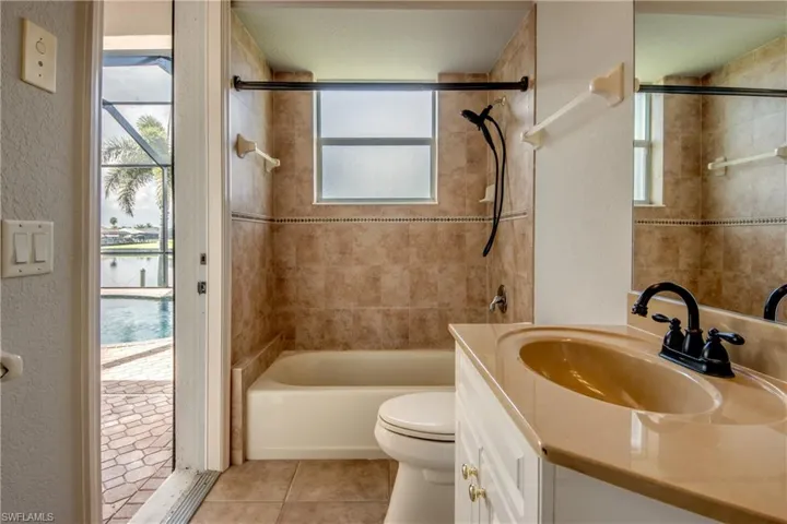 Full bathroom featuring vanity, tile patterned floors, tiled shower / bath, and toilet