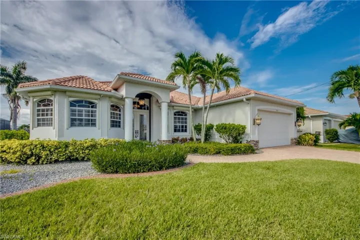 Mediterranean / spanish-style home featuring a garage and a front lawn