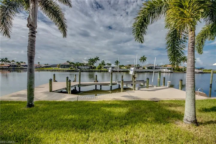 Dock area featuring a water view and a yard