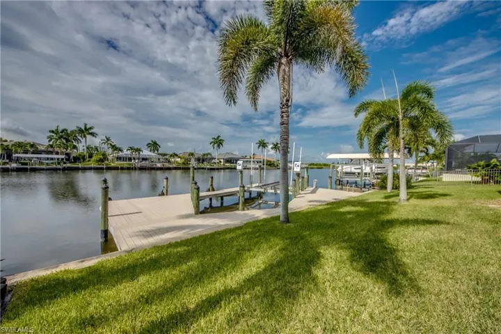Dock area with a yard and a water view
